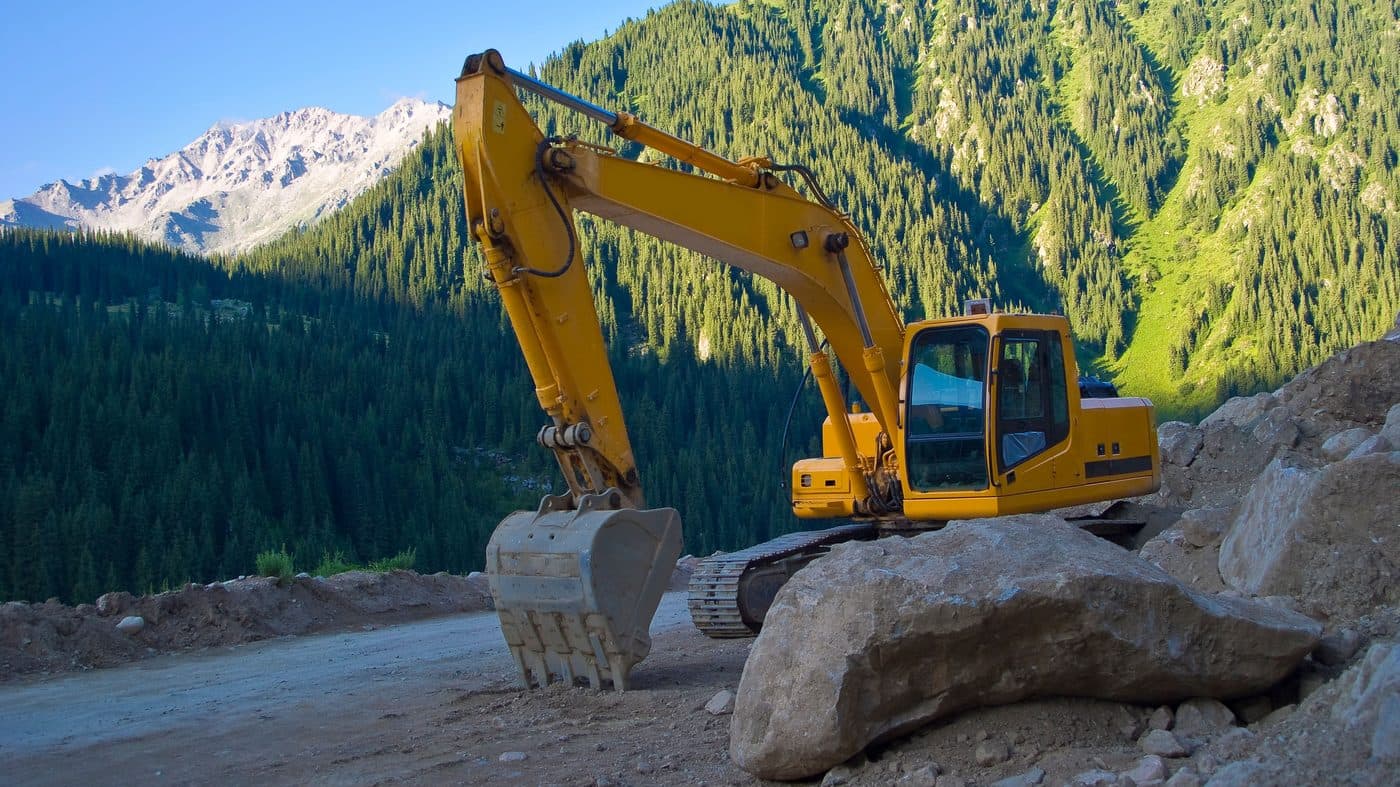 A tracked excavator parked on a mountain haul road