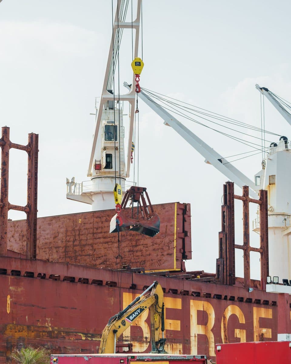 A crane grab working the open hold of a bulk carrier